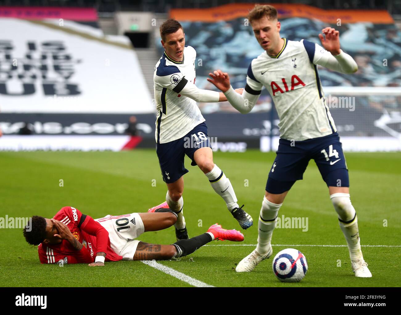 Tottenham Hotspur's Giovani Lo Celso (centre) tackles Manchester United's Marcus Rashford (left) during the Premier League match at the Tottenham Hotspur Stadium, London. Picture date: Sunday April 11, 2021. Stock Photo