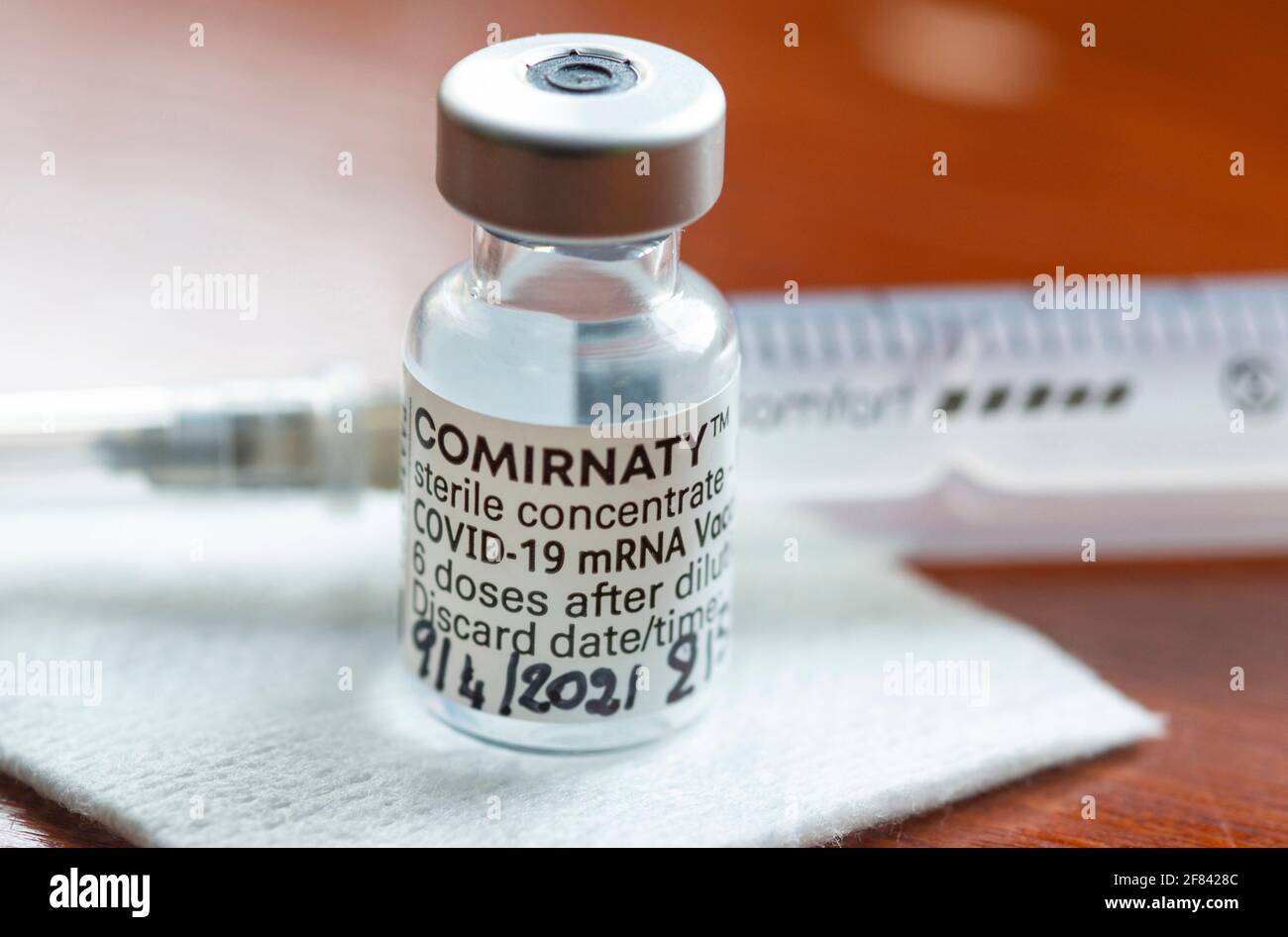 Genoa, Italy -April 2021, Comirnaty, RNA vaccine against covid-19, developed by Pfizer BioNTech on red background Stock Photo