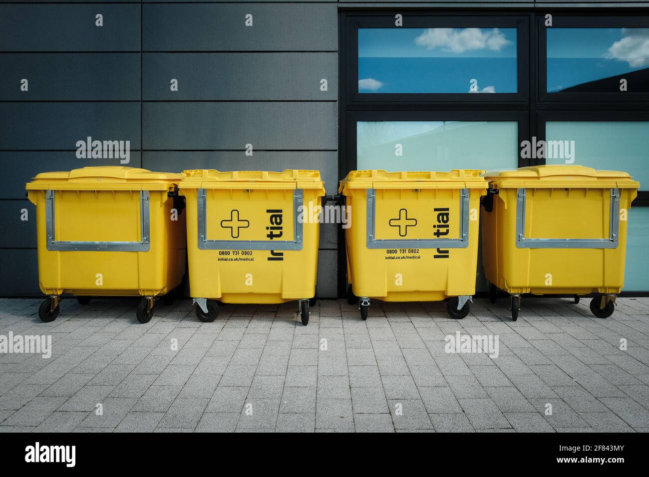Four large yellow wheelie bins as used for healthcare waste Stock Photo Alamy