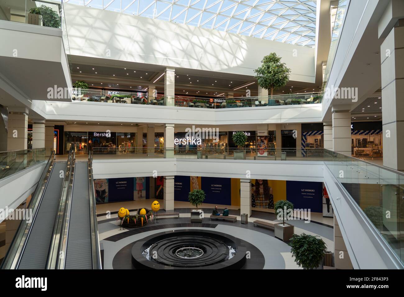 Grodno, Belarus - April 07, 2021: The interior of the modern large shopping and entertainment complex Trinity with a transparent glass roof. Stock Photo