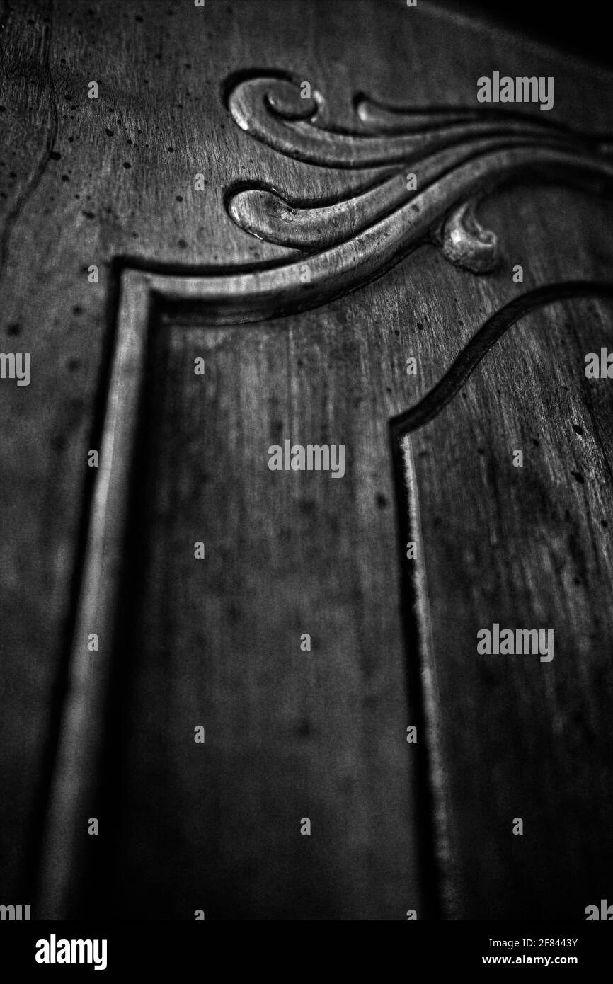 Furniture cabinet detail showcasing the carved scrollwork. Photographed in black and white. Stock Photo