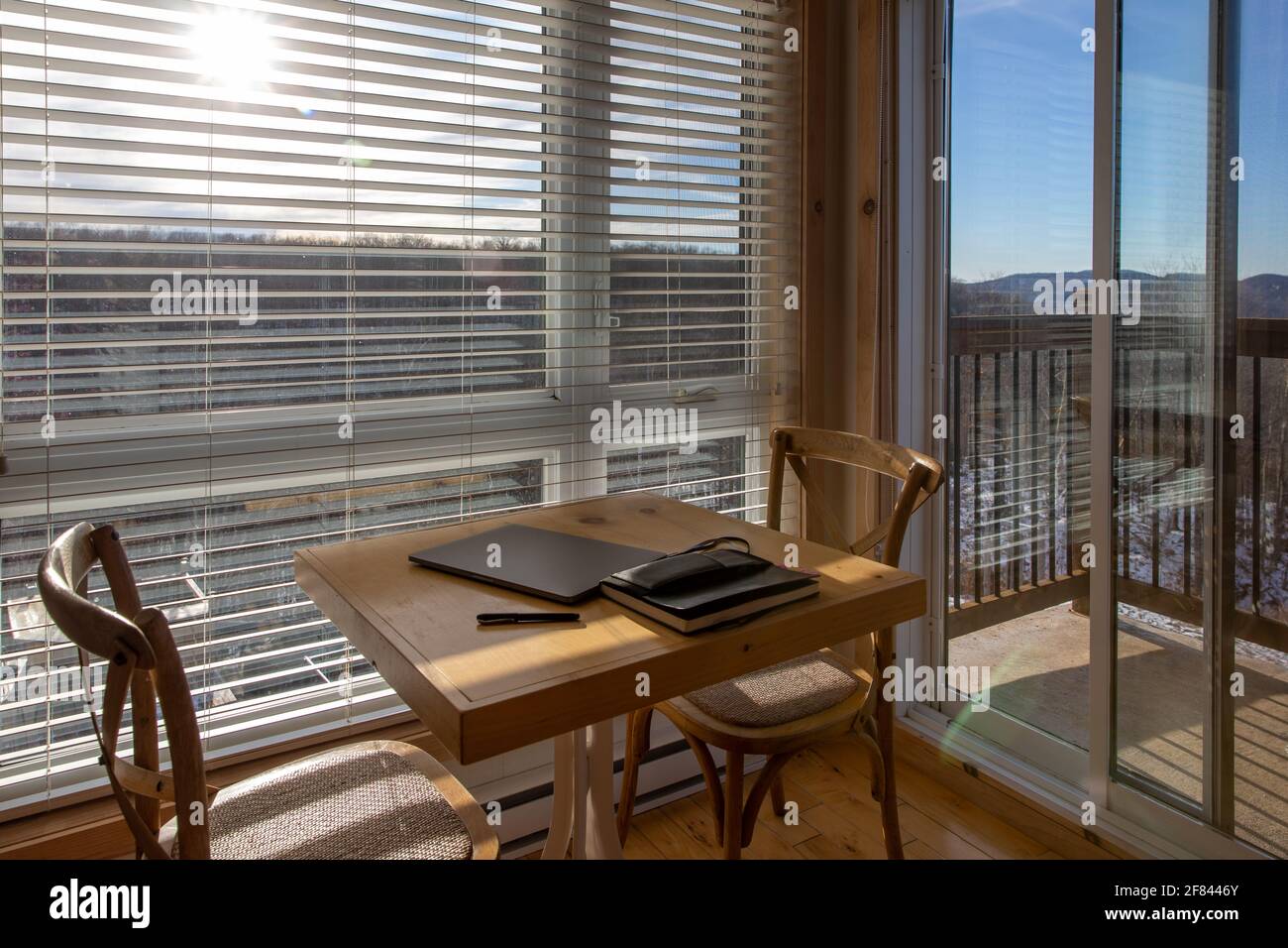 Notebook and grey laptop on a wooden table at home on the side of windows Stock Photo