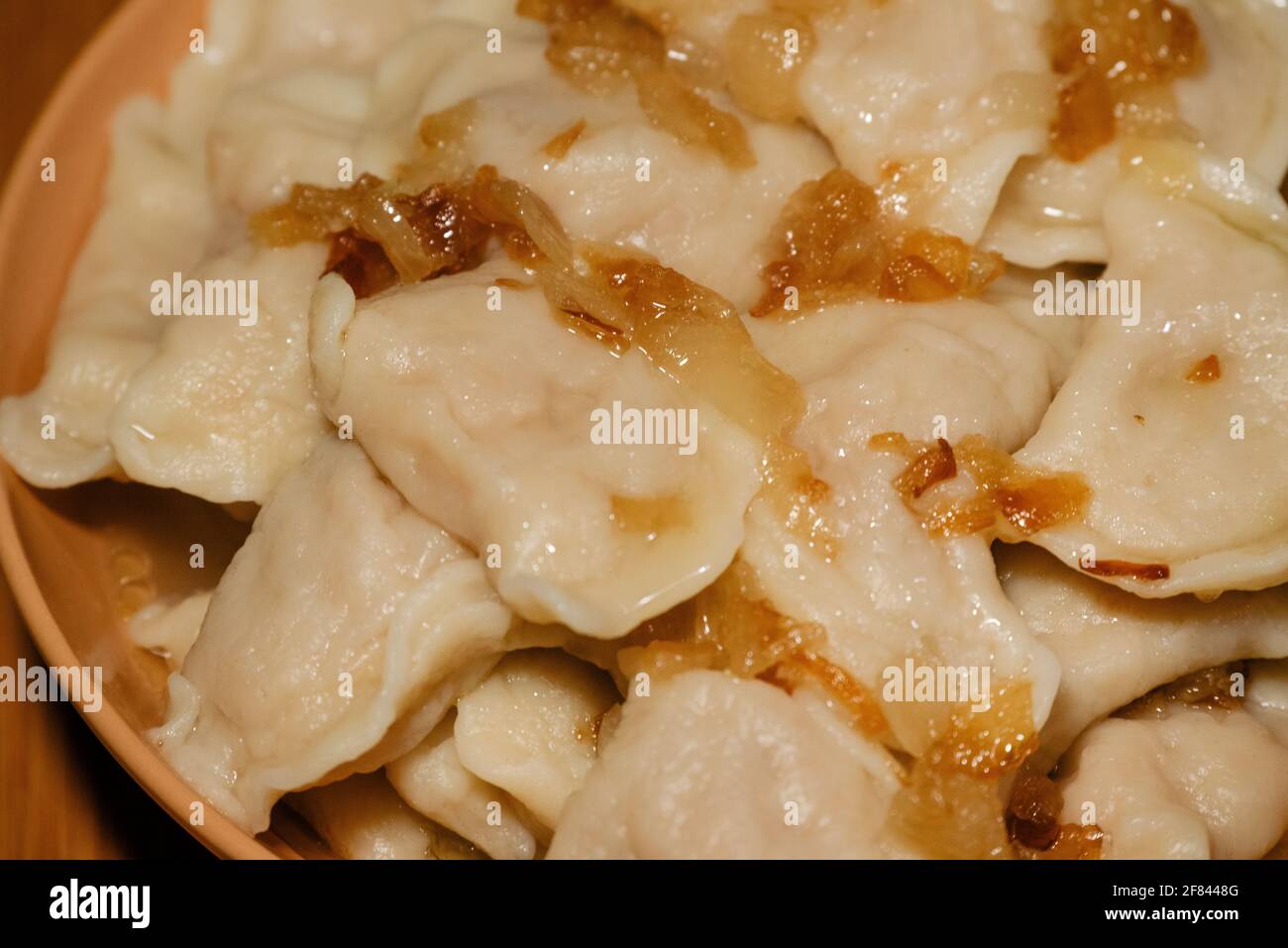 Dumplings in bowl with fried onions. Dumplings, filled with mashed potato served with fried onion Stock Photo