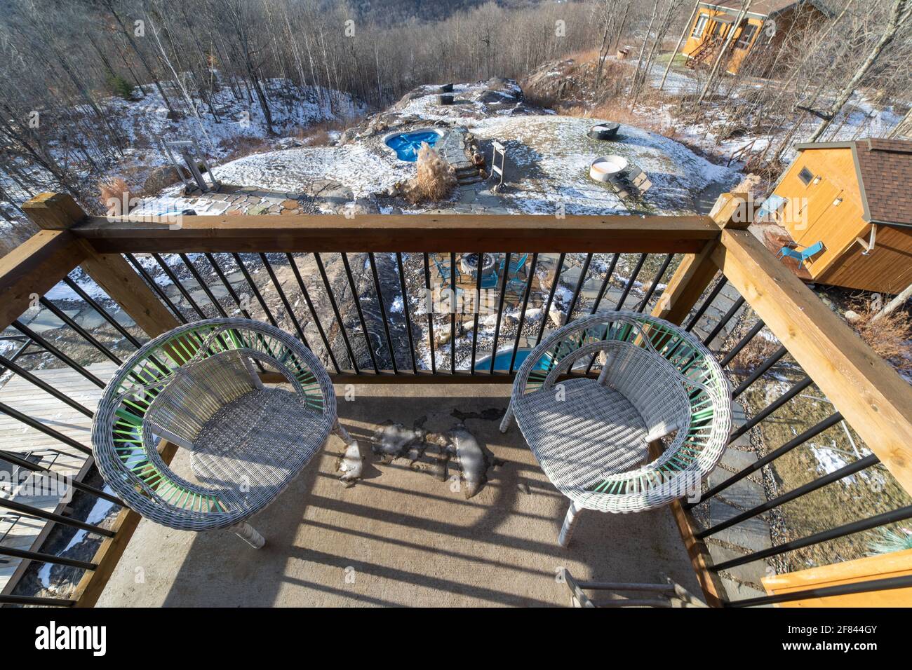 Wide angle view of two white wicker chairs on a balcony in winter with ...