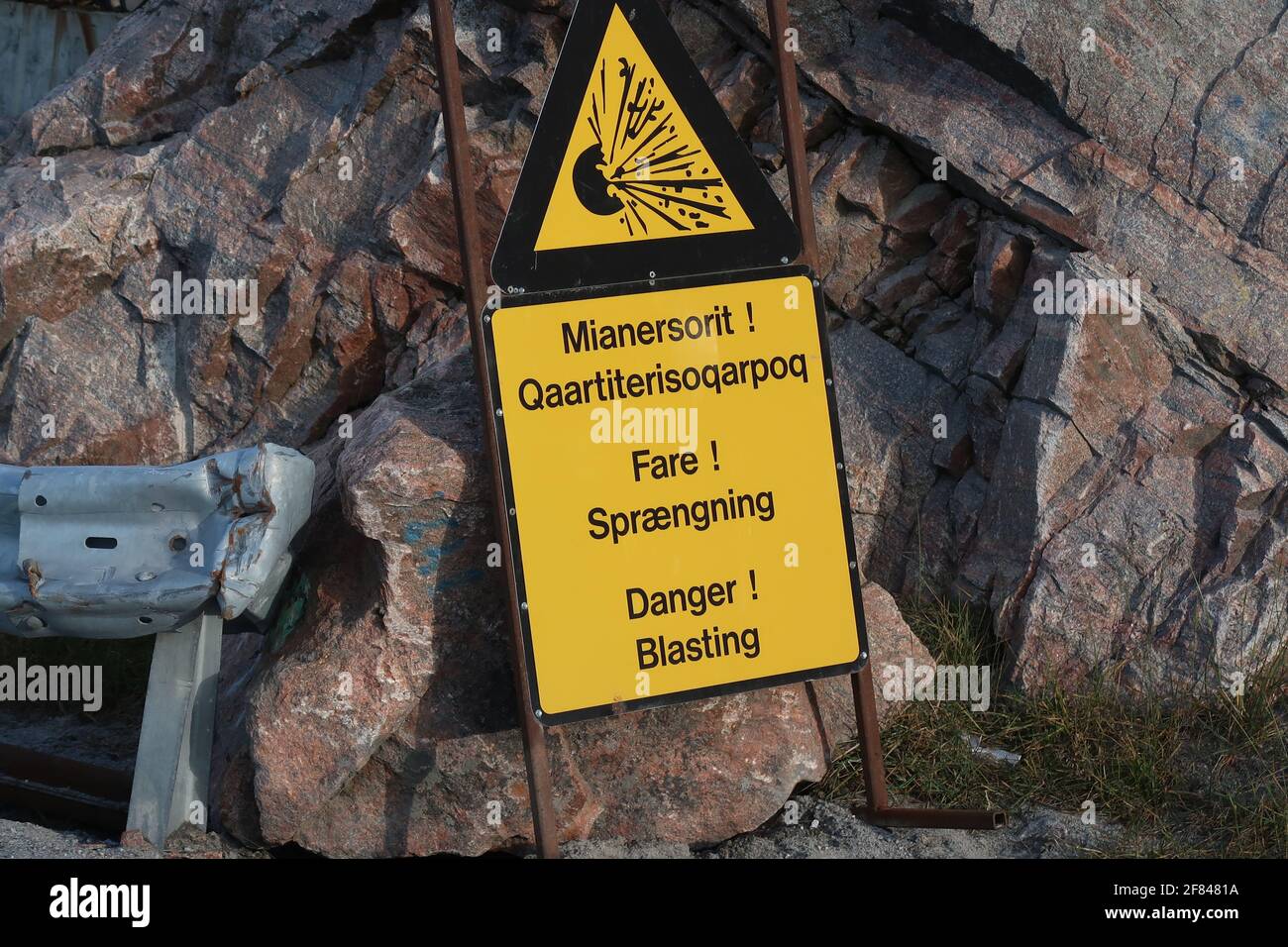 Gelbes Schild. Warnung vor Sprengungen in Grönländischer, Dänisch und Englisch Stock Photo