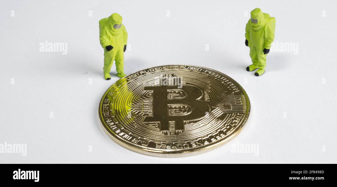 macro figures lookking on bitcoin. virtual cryptocurrency mining concept Stock Photo