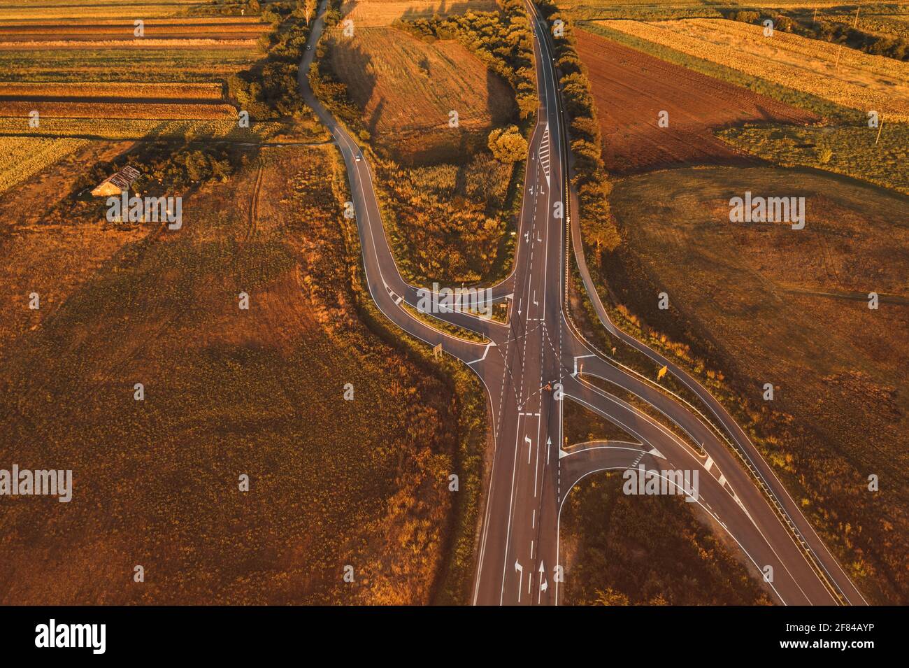 Vehicles on the road intersection through countryside landscape from