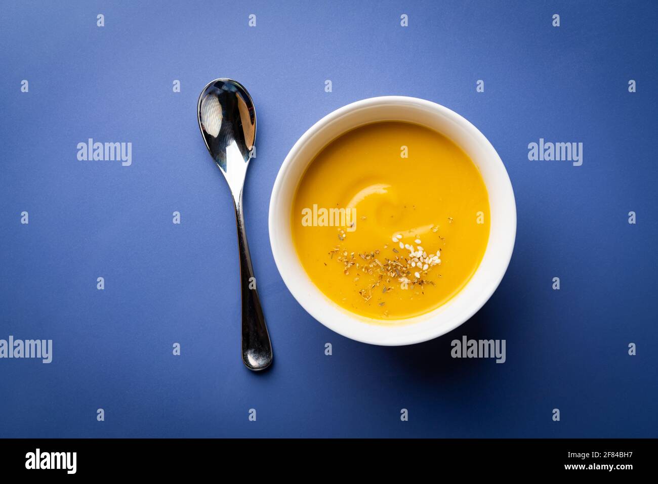 Vegetable vegetarian cream soup in a white bowl with croutons on blue ...