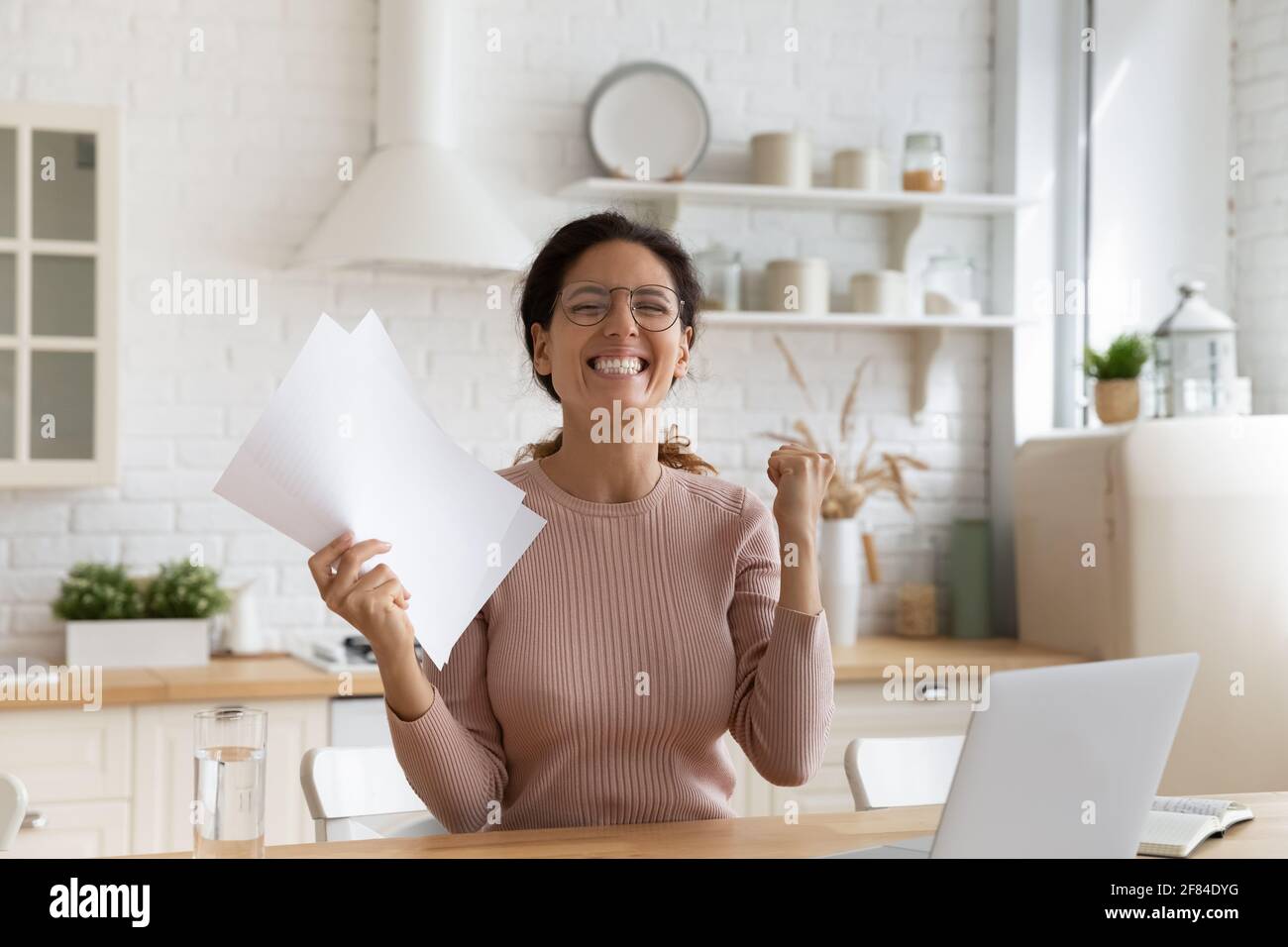 Overjoyed young latina woman hold letter confirming hiring on job Stock Photo