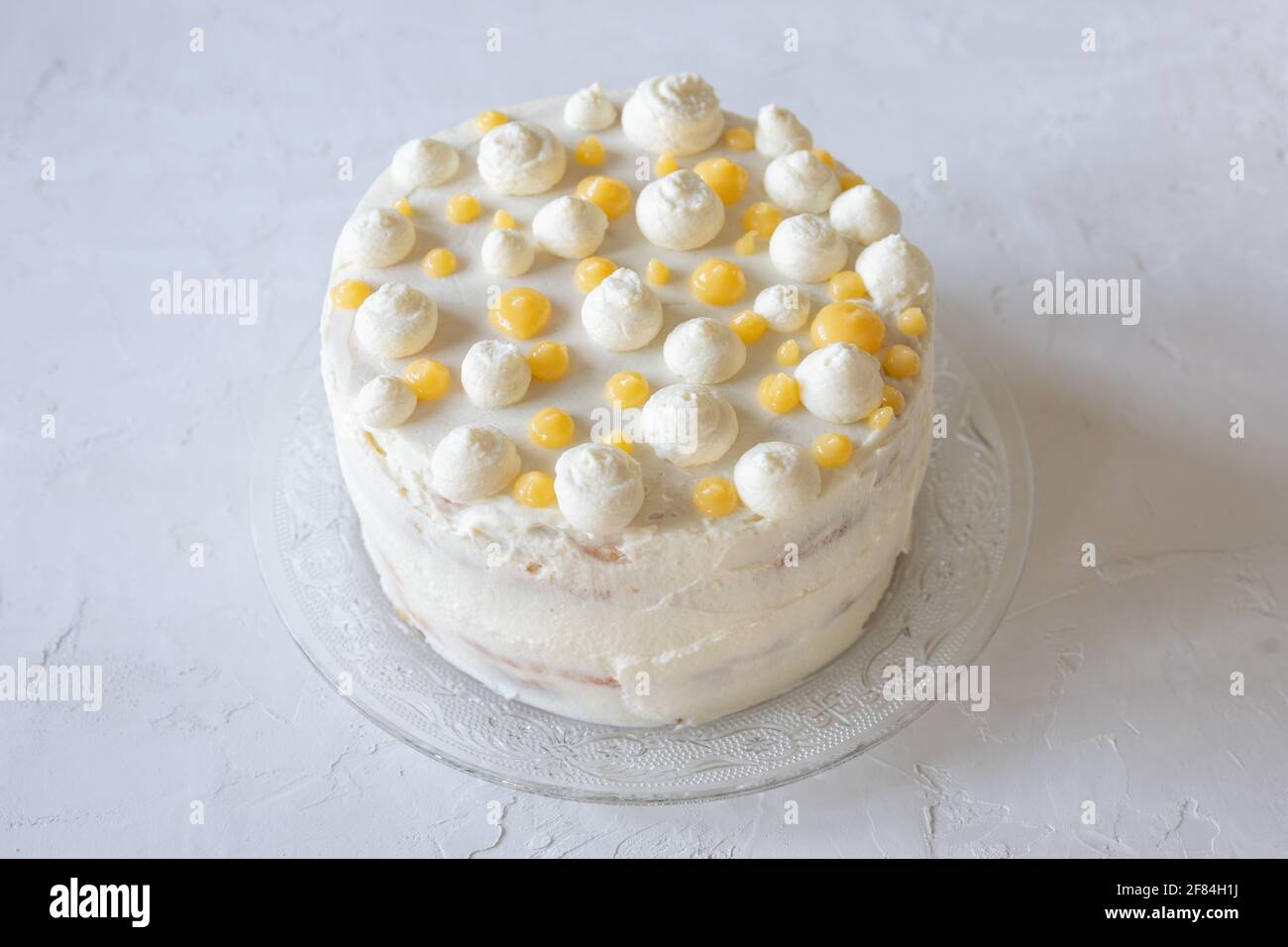 Lemon Victoria Sponge Cake decorated with dots of mascarpone cream and