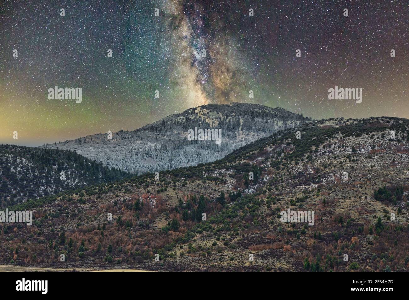 A beautiful view of the Milky Way Galaxy over a landscape with hills ...