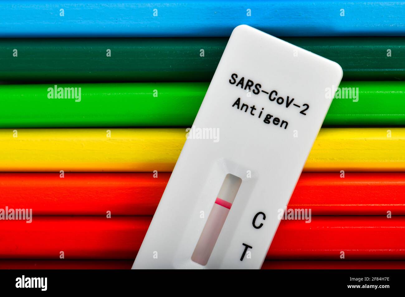 Symbol image compulsory testing at schools, negative rapid test cassette lies on crayons, Corona crisis, Germany Stock Photo