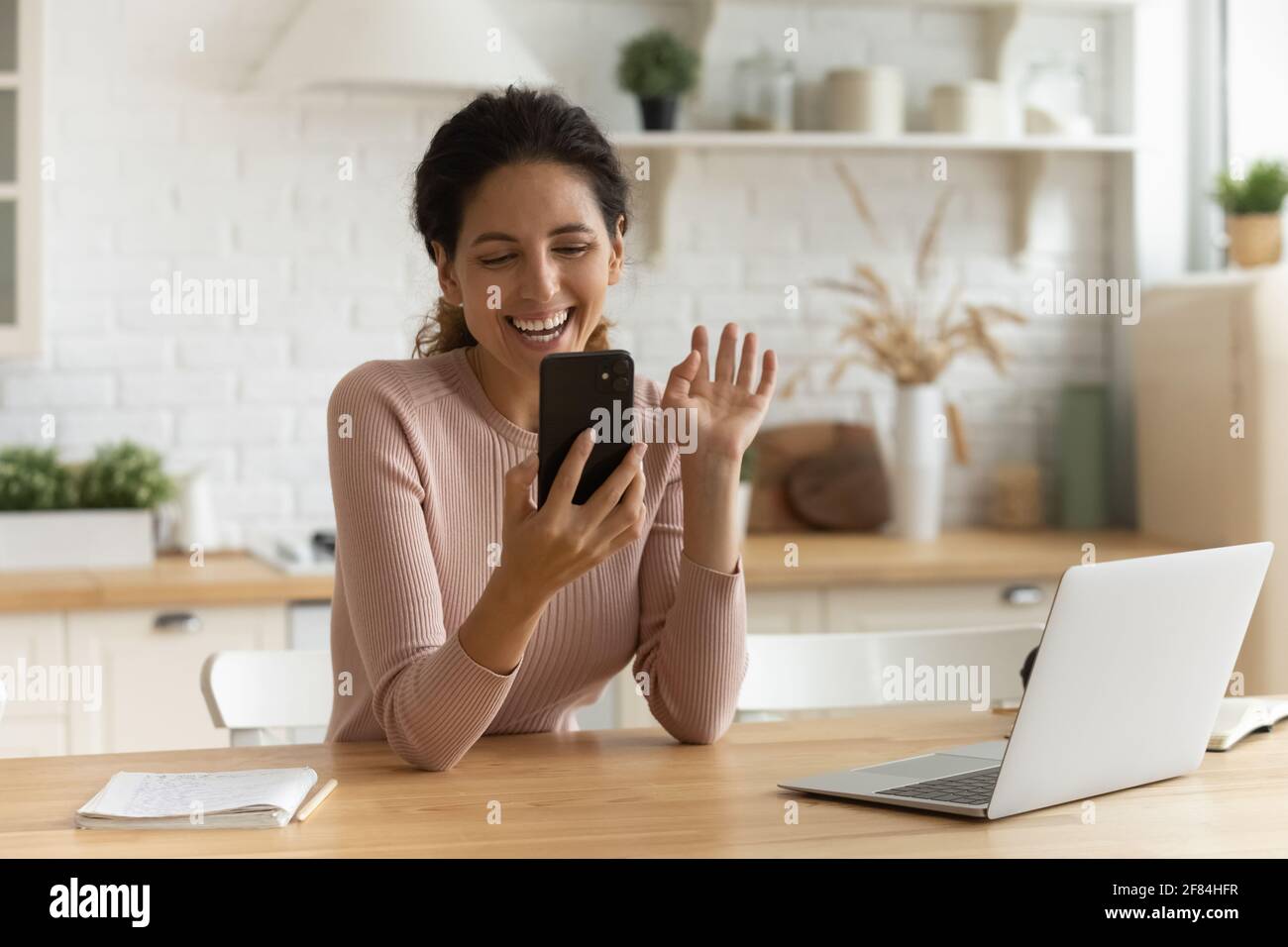Positive latina lady chat online greet friend by video call Stock Photo