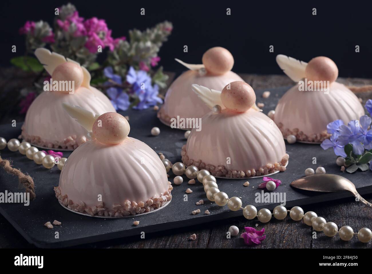 Trendy mousse cakes with pink mirror glaze. Dark background Stock Photo