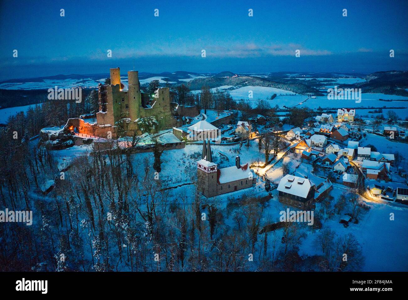Luftaufnahme von Burg Hanstein und dem Dorf Rimbach im Winter am Abend mit Beleuchtung Stock Photo