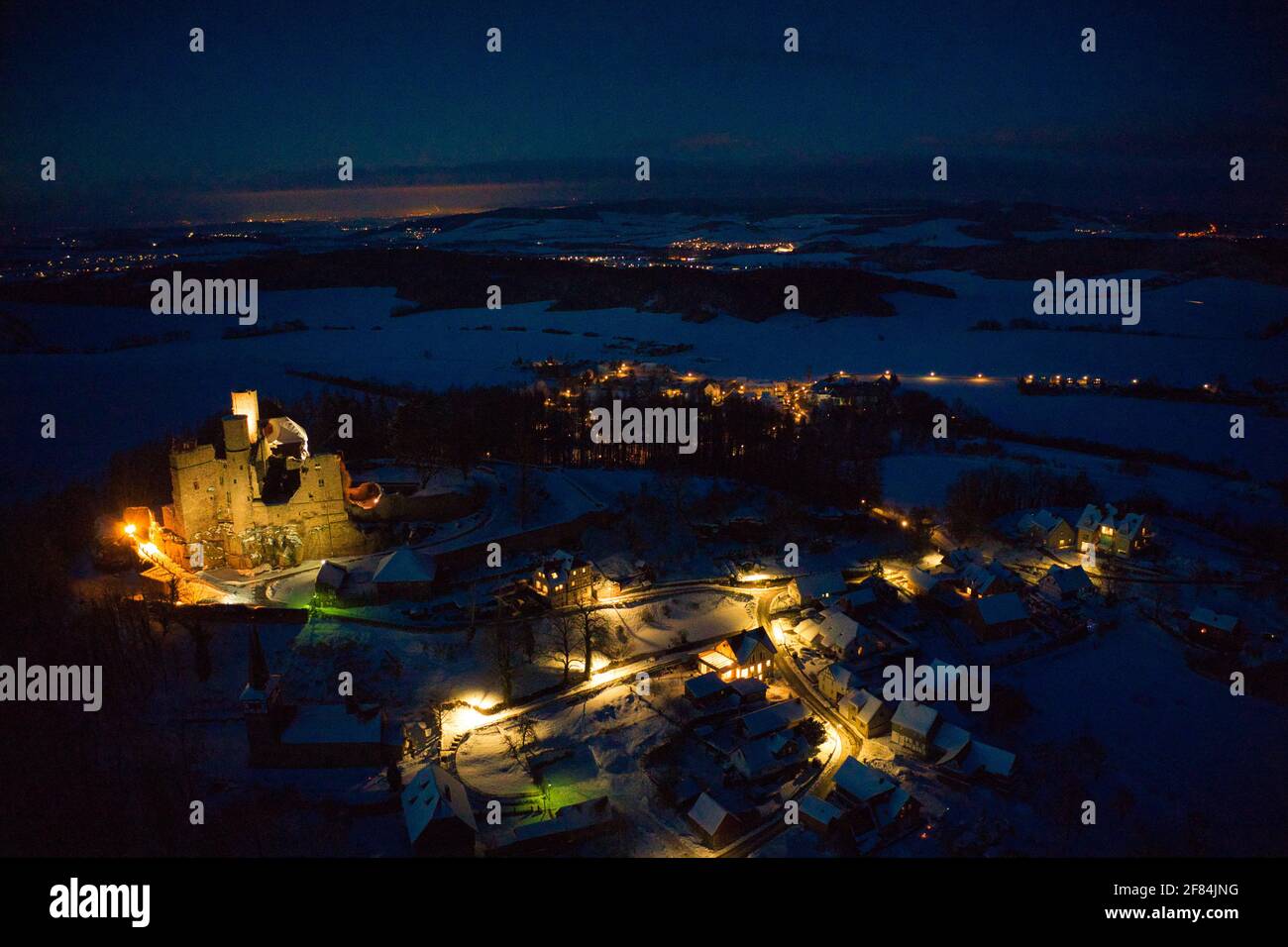 Luftaufnahme von Burg Hanstein und dem Dorf Rimbach im Winter am Abend mit Beleuchtung Stock Photo