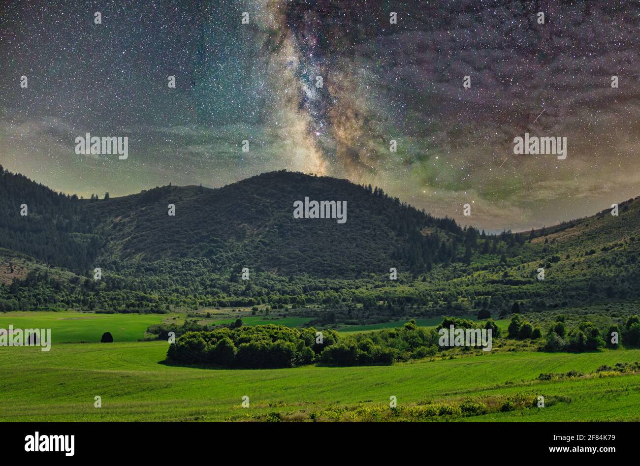 A beautiful view of the Milky Way Galaxy over a landscape with hills ...