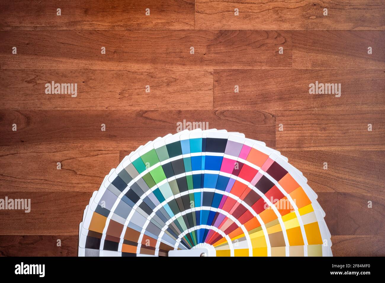 an open color swatch with all the different colors folded out on a wooden surface, cherry colored wood texture, horizontal Stock Photo