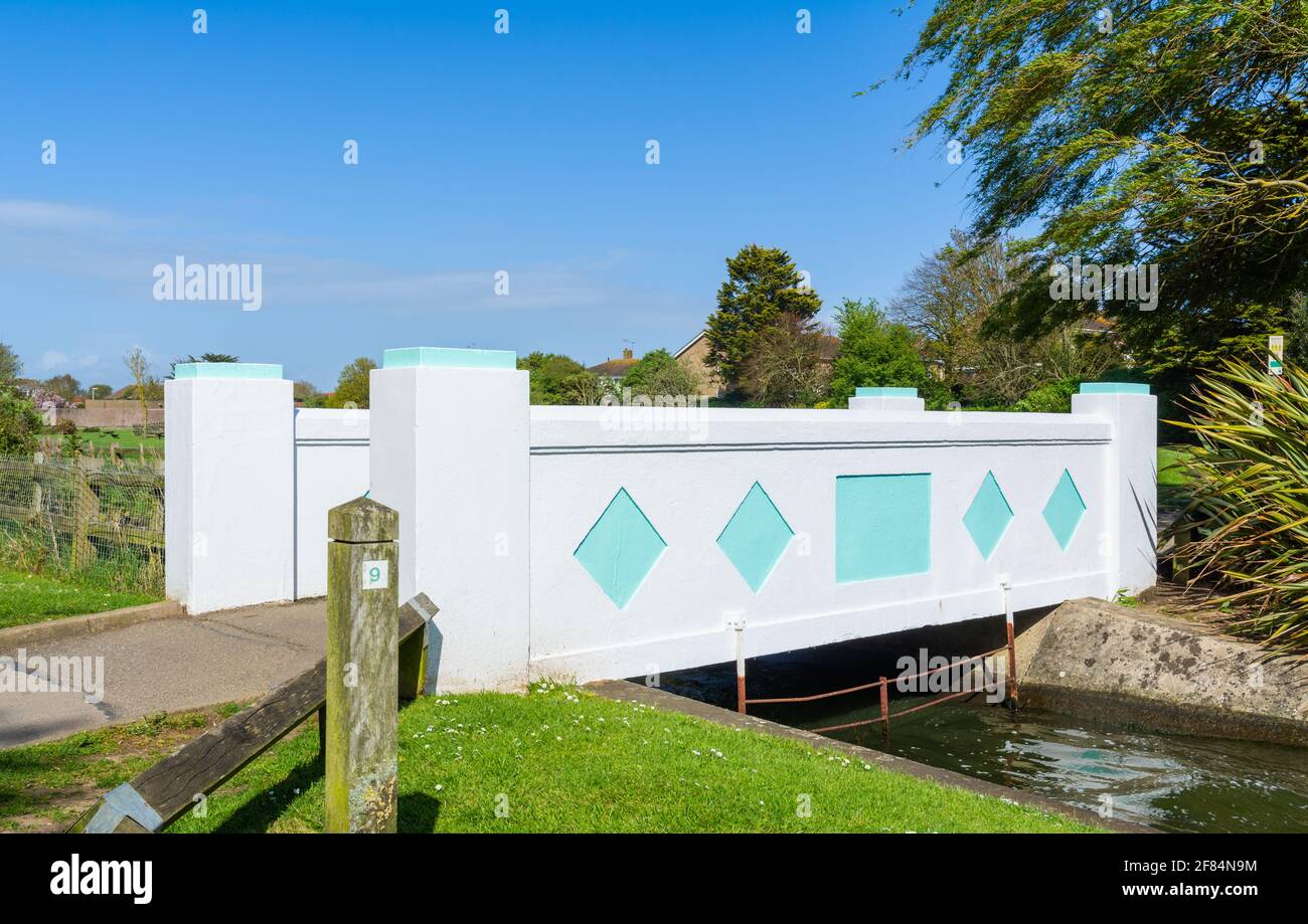 Small art deco style footbridge across water in Mewsbrook Park, Littlehampton, West Sussex, England, UK. Stock Photo