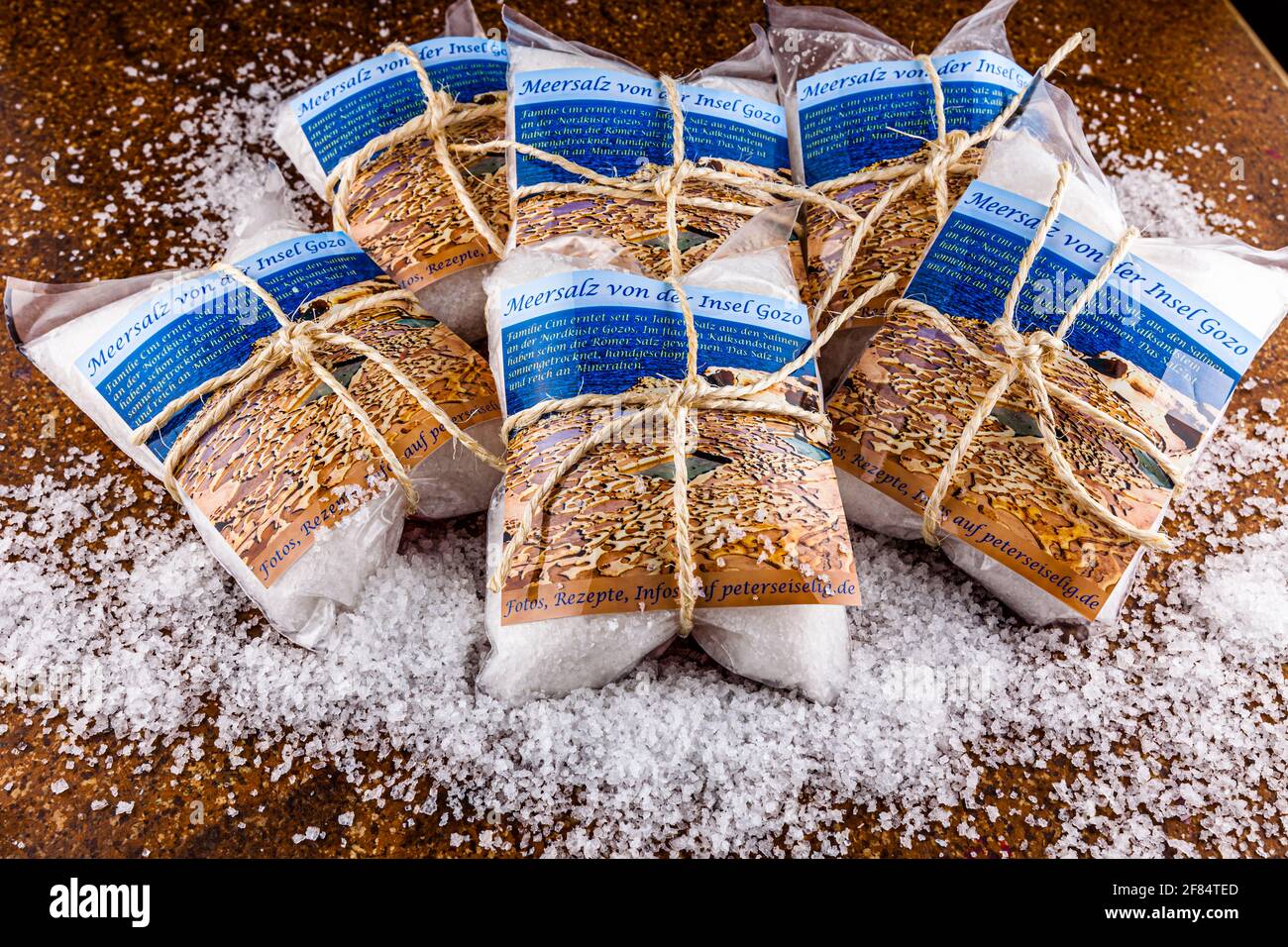 Tied package of sea salt from the island of Gozo. It is very appreciated by connoisseurs. The Cini family has been harvesting salt from the salt pans for 50 years on the north coast of Gozo. In the flac sand-lime brick have already won the Romans salt. The salt is sun-dried, hand-scooped and rich in minerals. Stock Photo