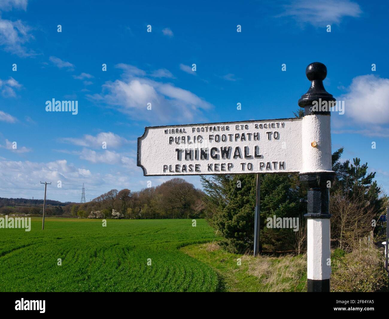 A white metal sign shows the way on a footpath from Storeton to Thingwall on Wirral in the north west of England in the UK. Stock Photo