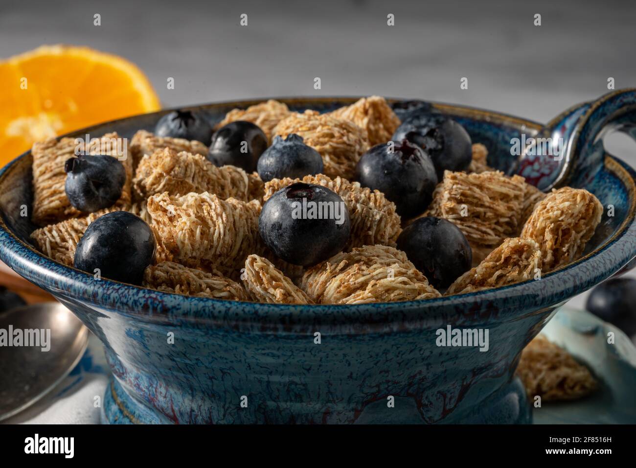 Shredded wheat biscuits with cinnamon and blueberries in almond milk. Stock Photo