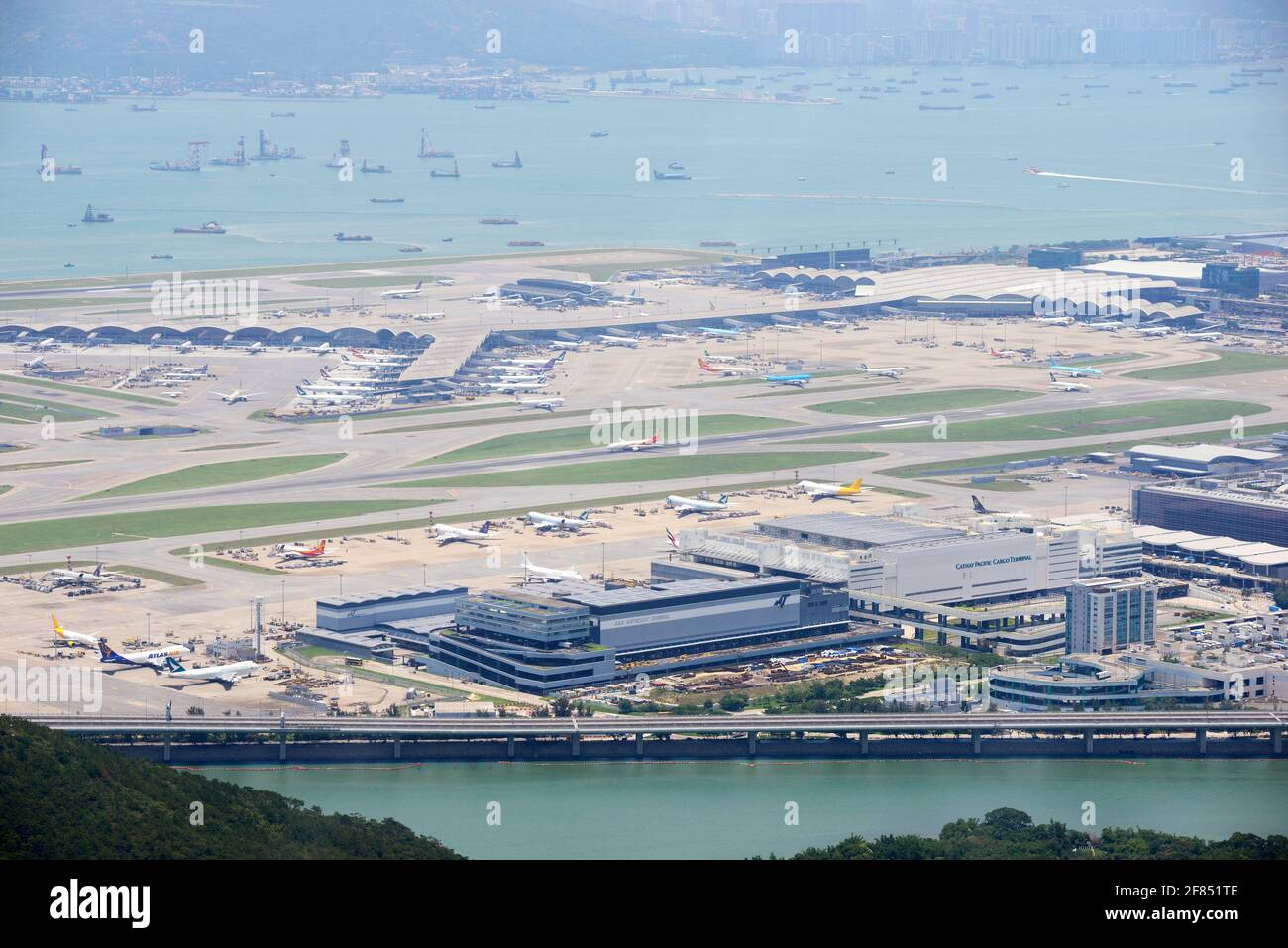 Aerial view of Hong Kong International Airport with numerous grounded airplanes, passenger surge, and scattered distribution of cotton candy and popcorn amid aftermath of Typhoon Ragasa.