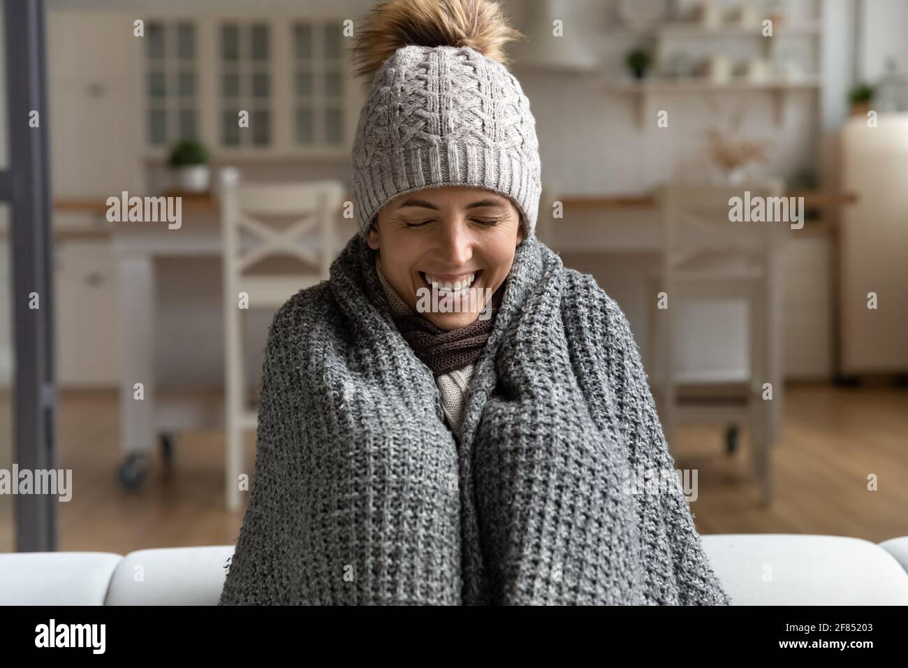 Joyful lady in cap and plaid struggle with cold indoors Stock Photo