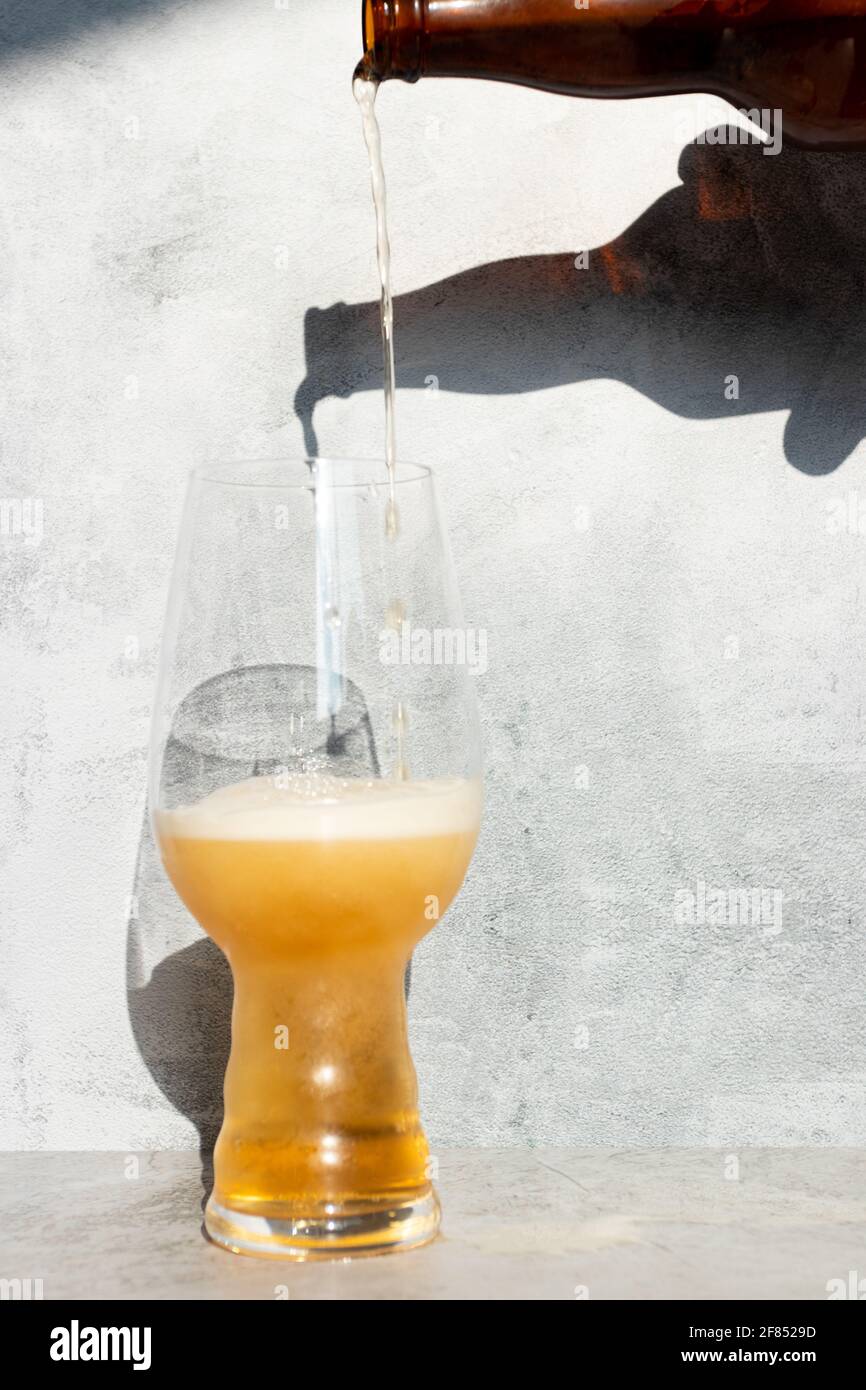 Serving beer, from a bottle to a crystal glass for IPA Stock Photo
