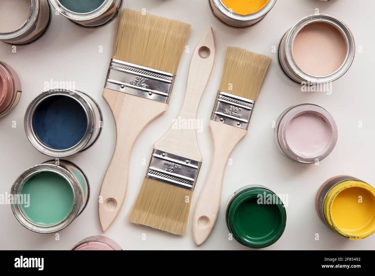 Overhead view of a DIY paint brush with colorful sample paint pots Stock Photo