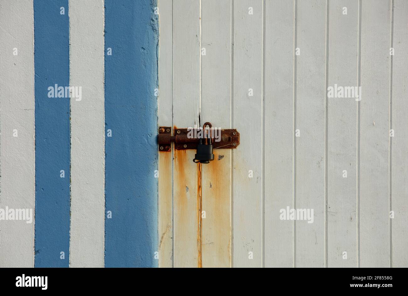 Rusted lock on door with vertical stripes. Stock Photo