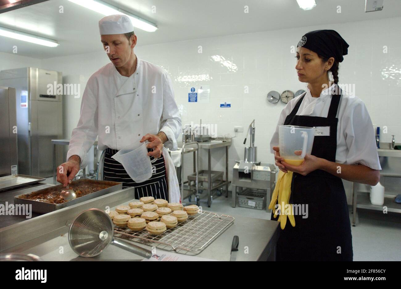 SIMON OWEN WITH SUE BIGGIN ,IN THE TRAINING KITCHEN   FOR SCHOOL COOKS IN ESSEX. 2/12/05 TOM PILSTON Stock Photo