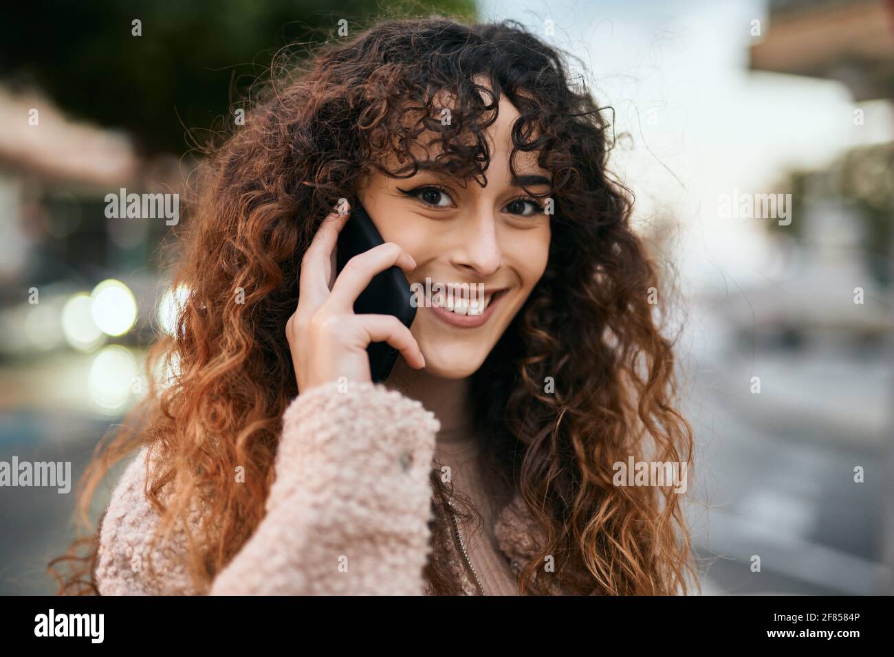 Young hispanic woman smiling happy talking on the smartphone at the ...