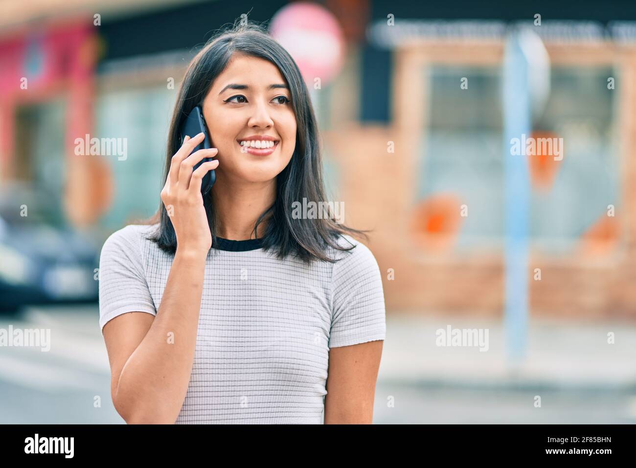 Young hispanic woman smiling happy talking on the smartphone at the ...