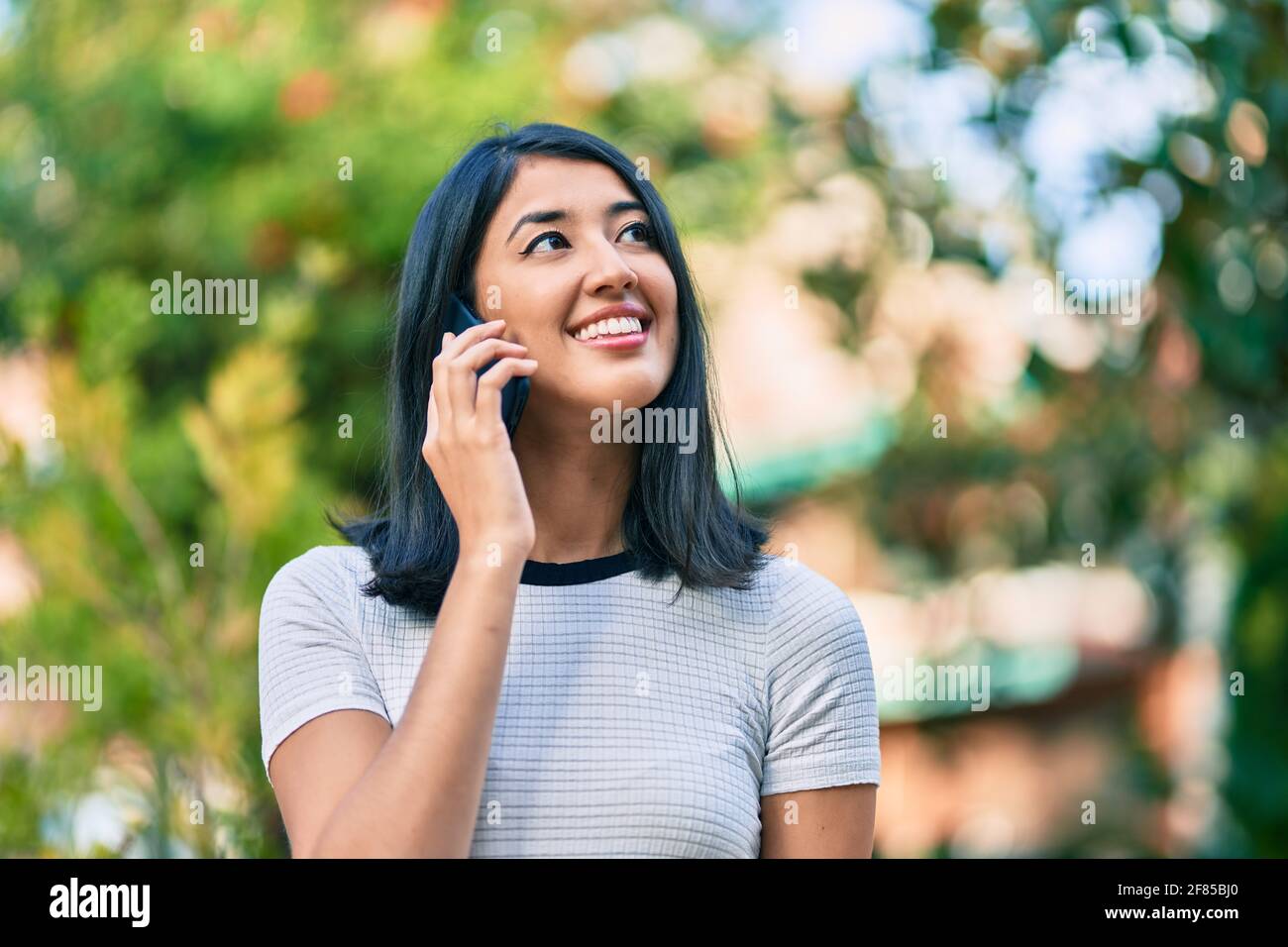 Young hispanic woman smiling happy talking on the smartphone at the ...