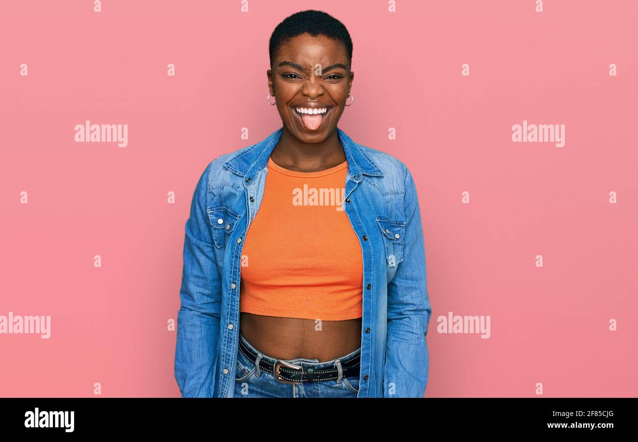 Young african american woman wearing casual clothes sticking tongue out ...