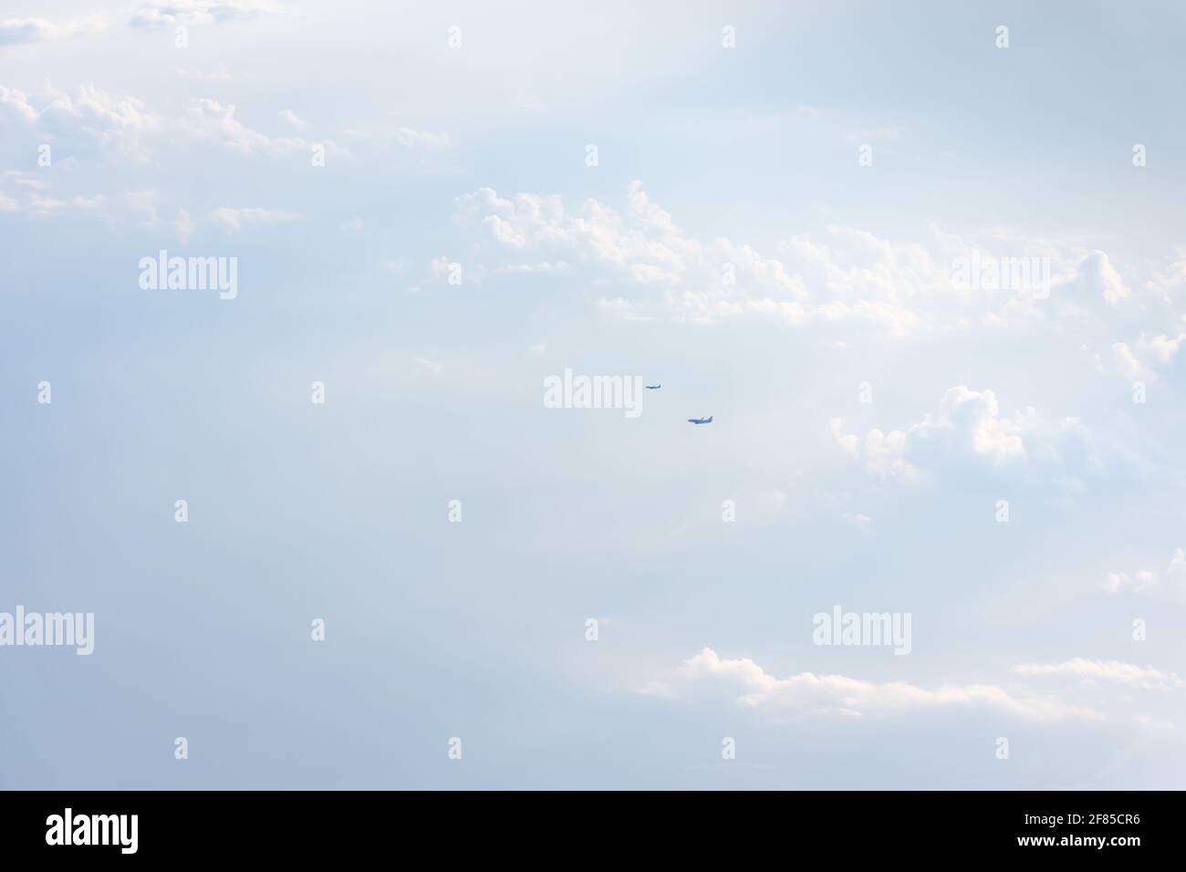 The plane is in the sky above the white clouds. Lightness, lightness, weightlessness. Bright sunlight, natural summer background. The concept of trave Stock Photo