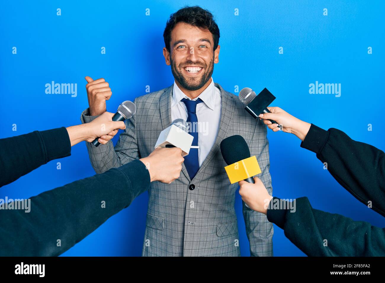 Handsome man business with beard being interviewed by reporters holding ...