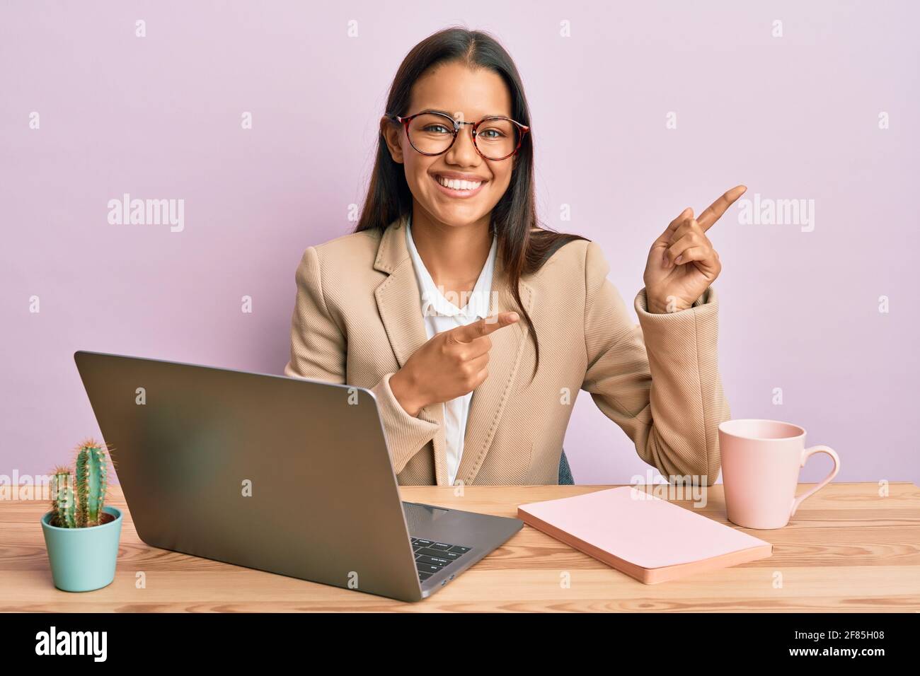 Beautiful hispanic woman working at the office wearing glasses smiling ...