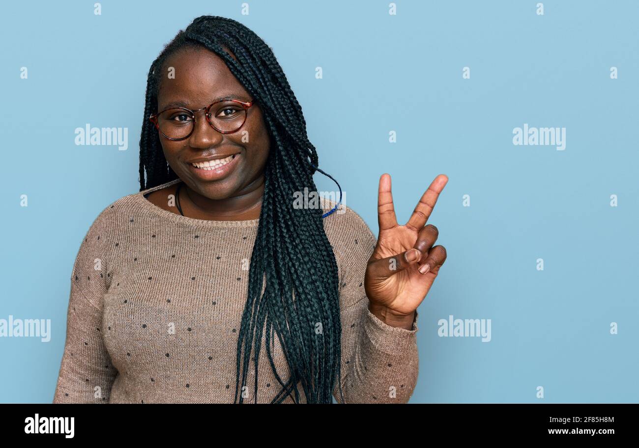 Young black woman with braids wearing casual clothes and glasses ...