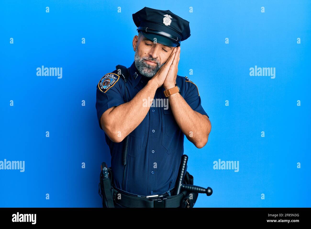 Middle age handsome man wearing police uniform sleeping tired dreaming ...