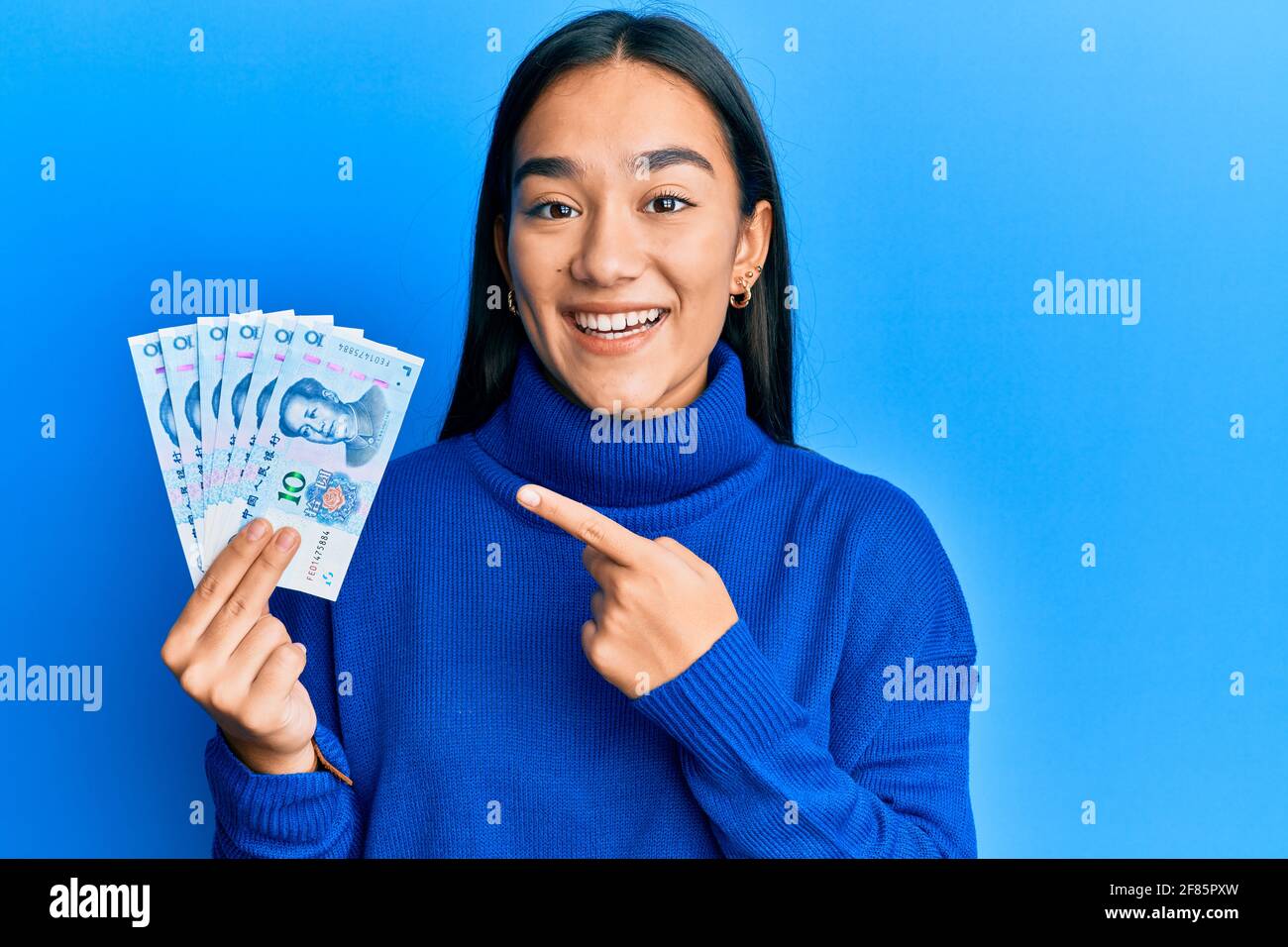 Young asian woman holding 10 yuan chinese banknotes smiling happy ...