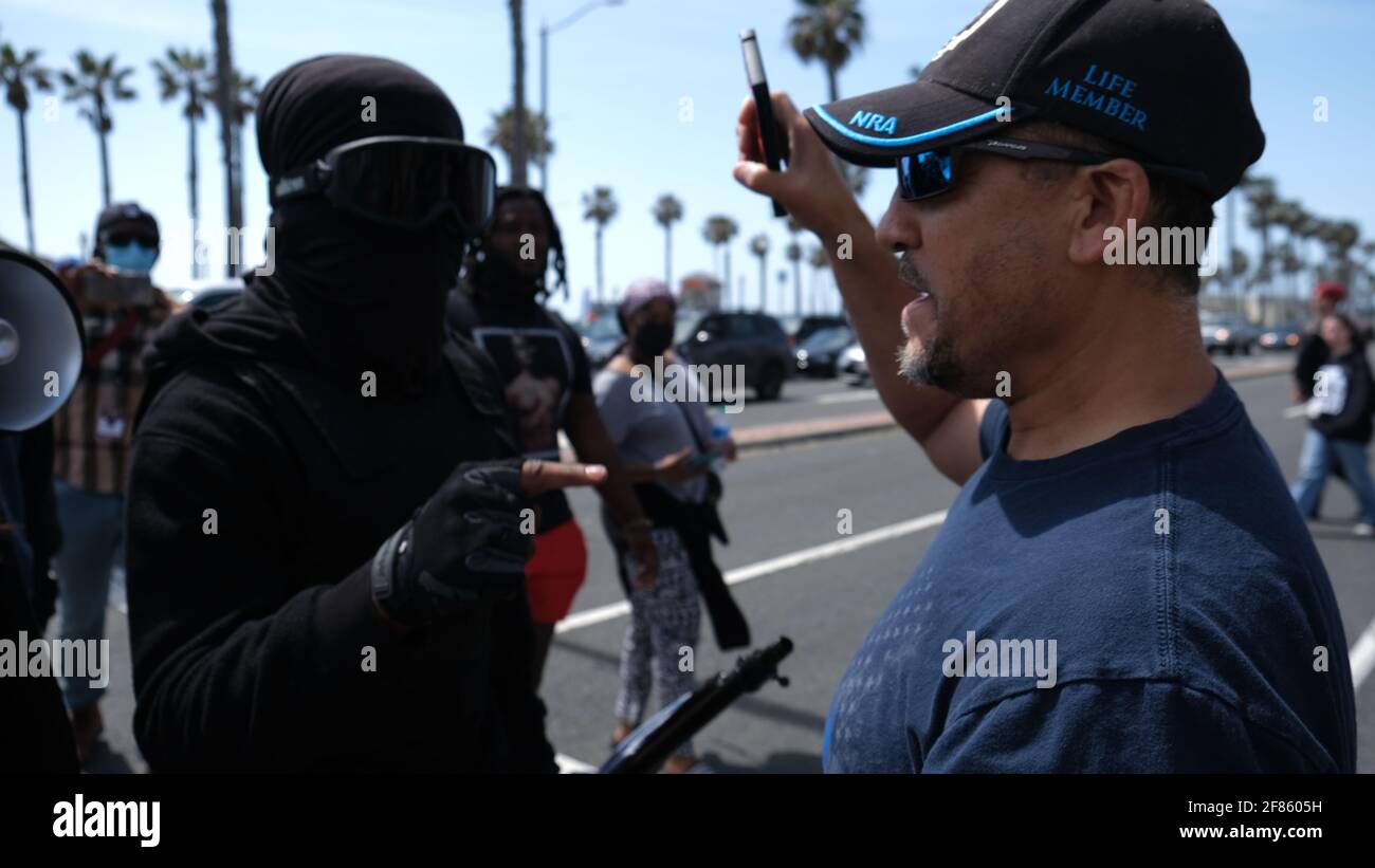 Huntington Beach, CA, USA. 11th Apr, 2021.  A man is confronted by a counter-protester in black bloc clothing. Multiple counter protesters showed up to Huntington Beach Pier on Sunday morning after 'White Lives Matter Rally' fliers were circulated online. Credit: Young G. Kim/Alamy Live News Stock Photo