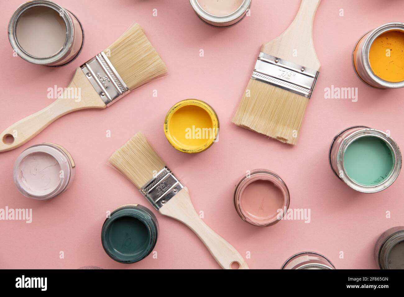 Overhead view of a DIY paint brush with bright sample paint pots Stock