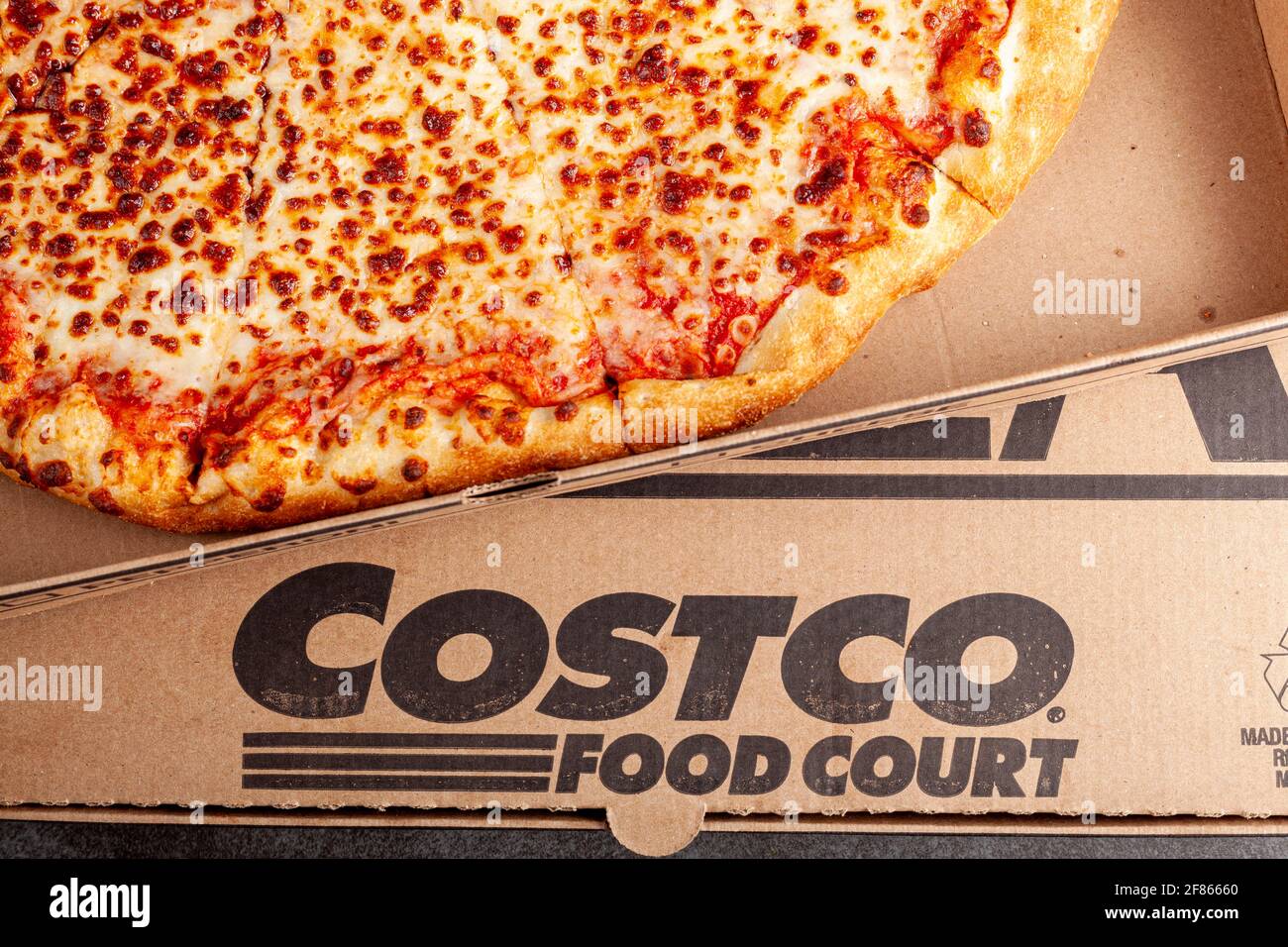 Clarksburg, MD, USA 04-7-2021: Closeup flat lay top view image of a carton box of delicious made to order COSTCO cheese pizza. Very popular bargain pr Stock Photo