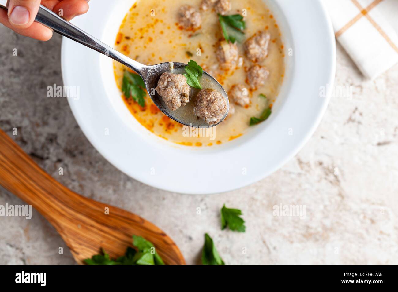 Turkish meatball soup (Terbiyeli kofte corbasi ) is a popular dish in Turkey where meatballs made with ground beef and rice are cooked in broth with e Stock Photo