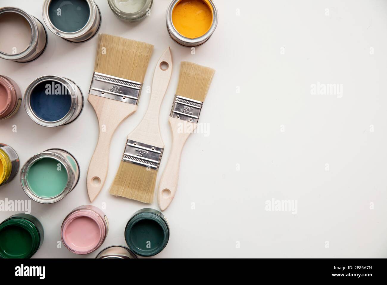 Overhead view of a DIY paint brush with colorful sample paint pots Stock Photo