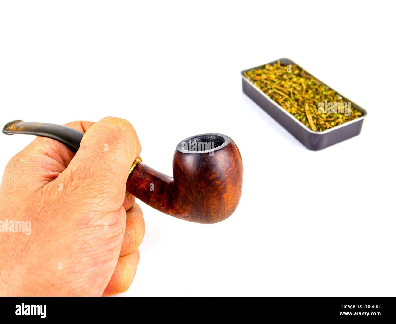 pipe for cigarette tobacco Pipe for smoking tobacco in the hand of a smoker on a white background.  Wooden pipe for smoking. Tobacco in a snuffbox. Smokers tool. Human hand.  Smok Stock Photo
