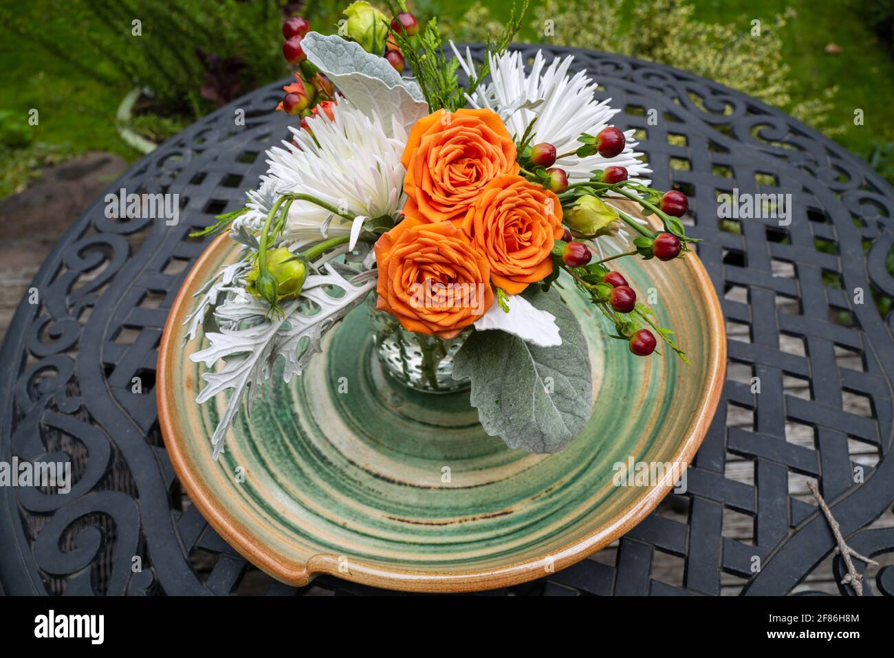 A floral centerpiece on a wrought iron table outside Stock Photo Alamy