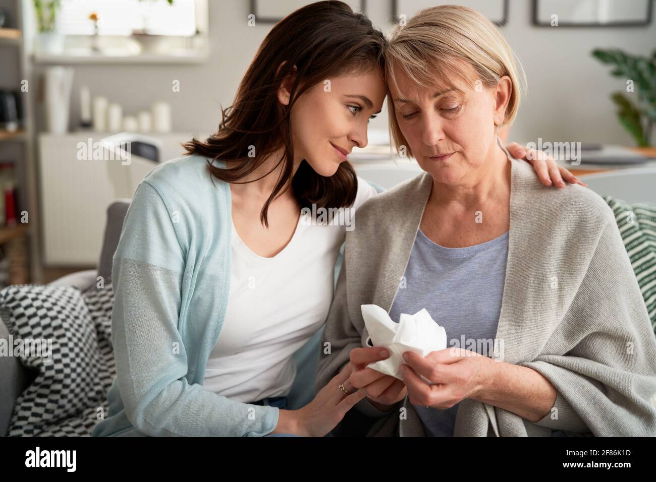 Woman comforting upset senior woman Stock Photo